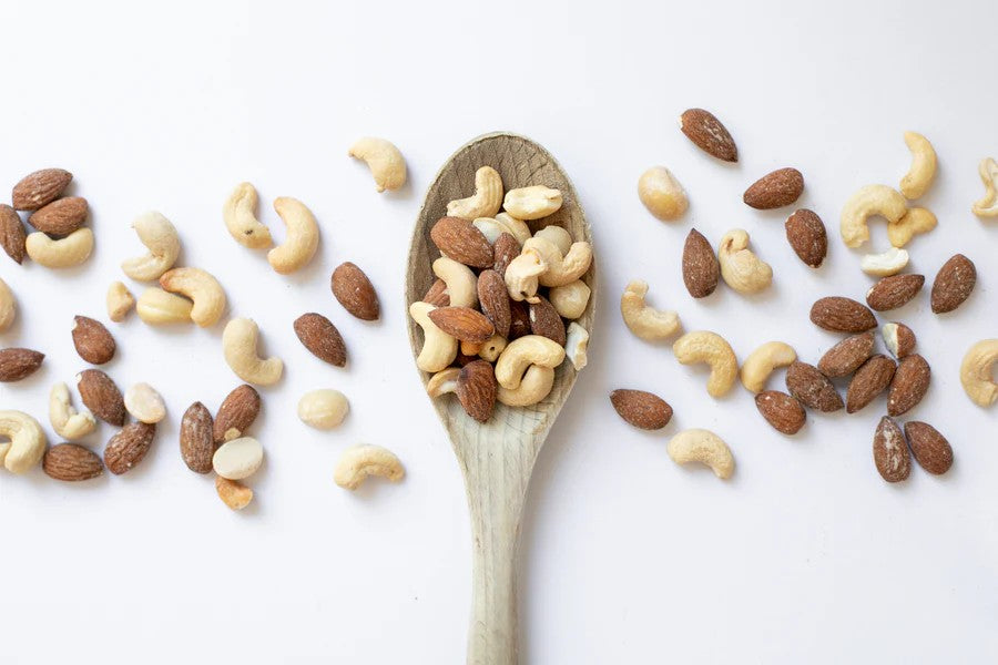 Wooden spoon filled with a mix of nuts on a white background photo from Nutworks
