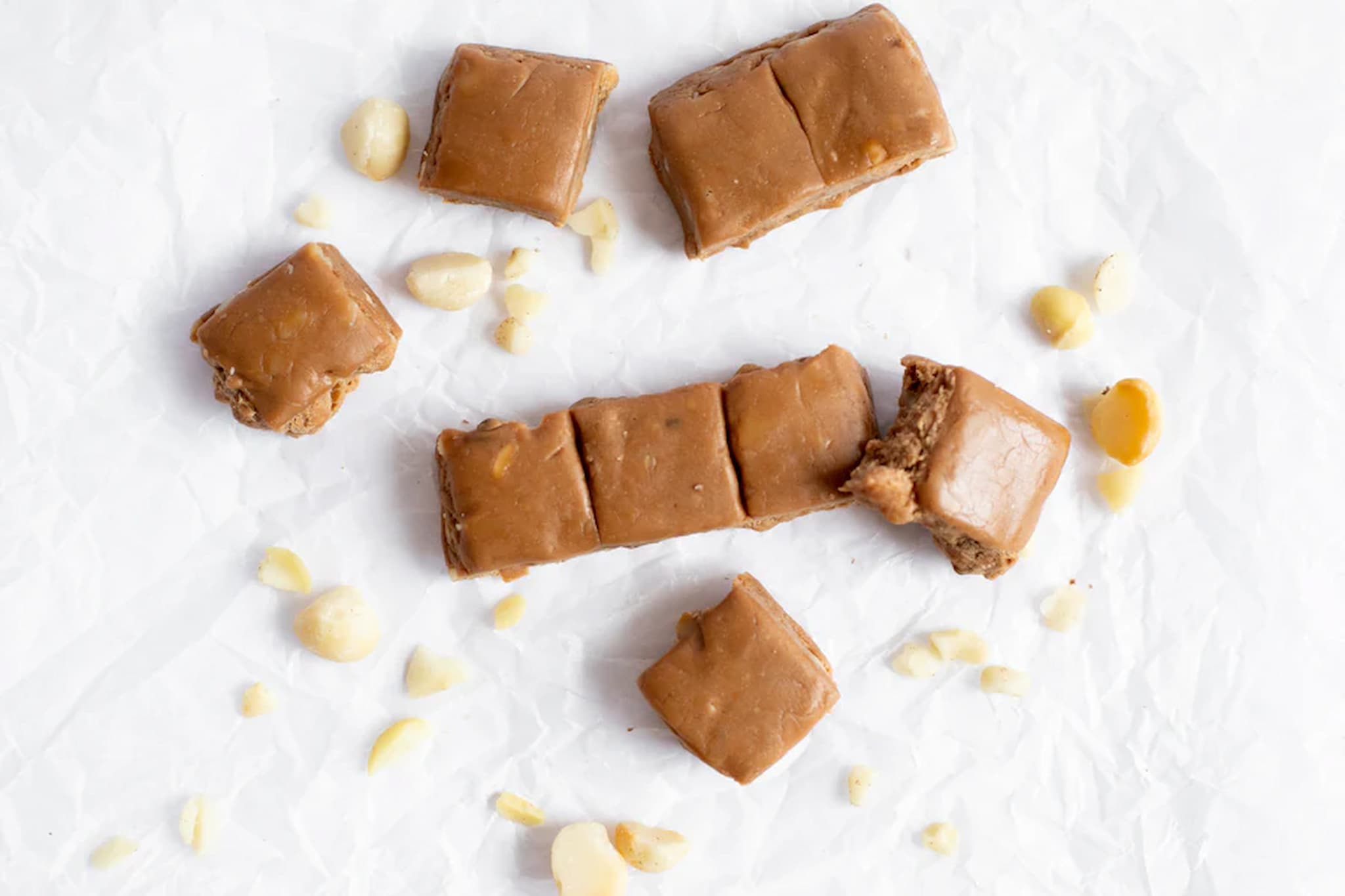 Macadamia Caramel fudge squares with nuts on a white background from Nutworks