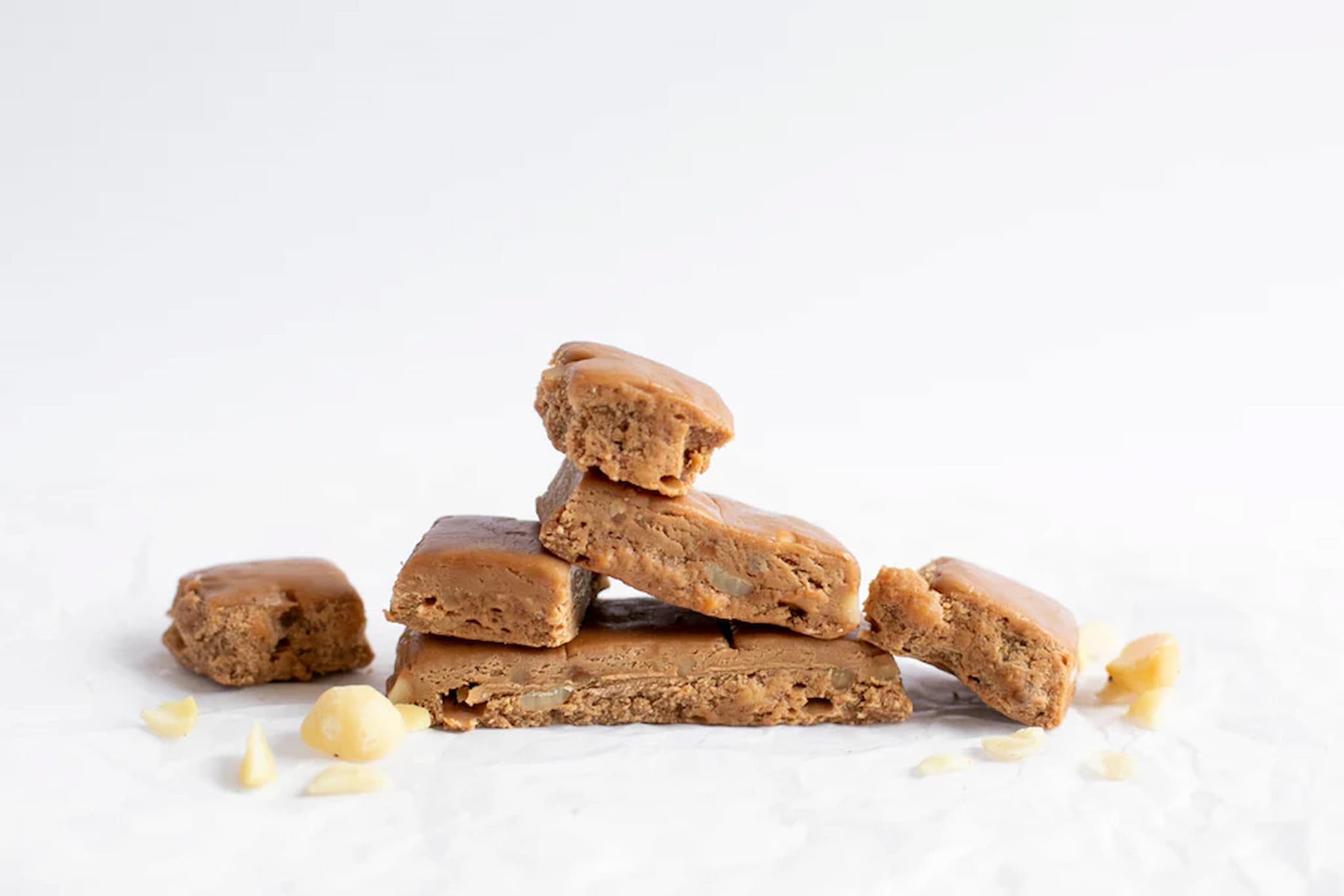 Caramel macadamia fudge with roasted Australian macadamia nuts in Pieces on a white surface from Nutworks