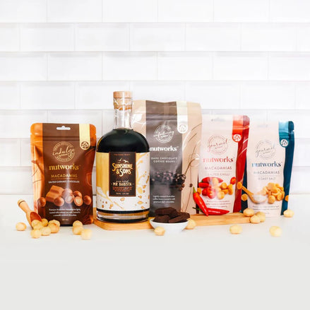 Assorted nut-based products including a bottle and packages on a white surface with a white tiled wall background photo from Nutworks.