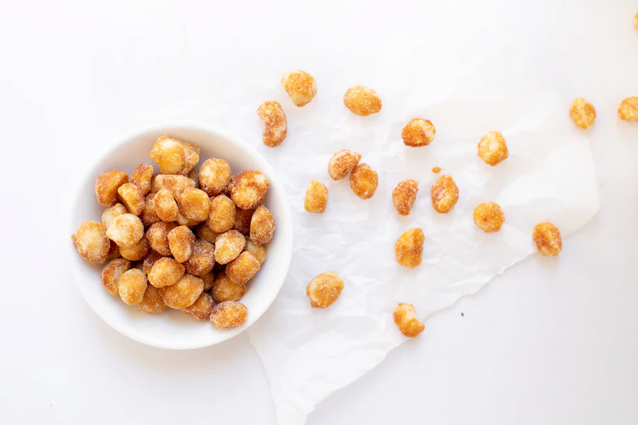 Manuka honey macadamias in a white bowl on a light background photo from Nutworks.
