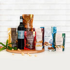 Assorted macadamia nut packages and a bottle of wine on a wooden board with a white tiled background photo from Nutworks.